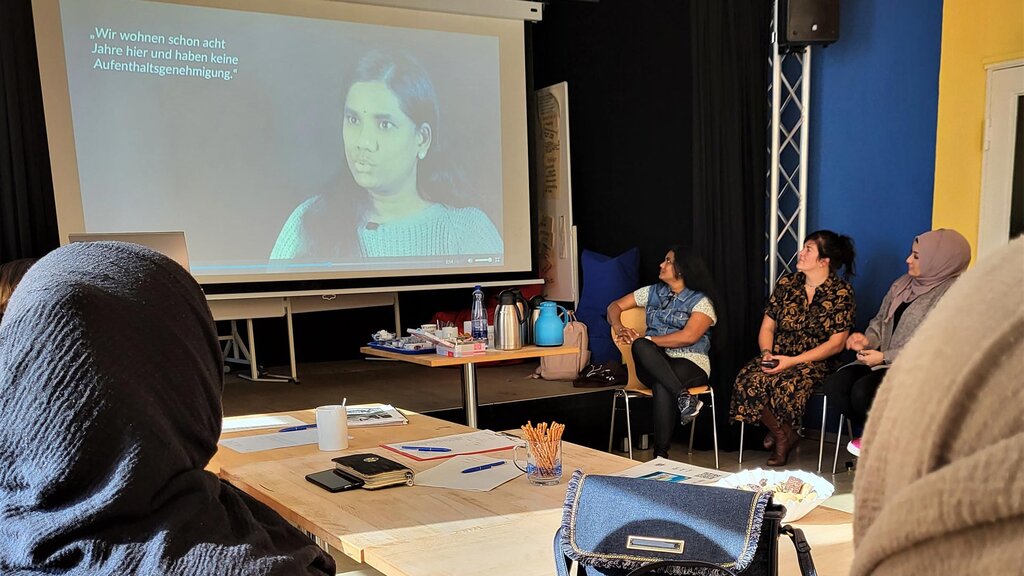 Klientinnen des Beratungstermin schauen gemeinsam einen Film in einem Schulungsraum.